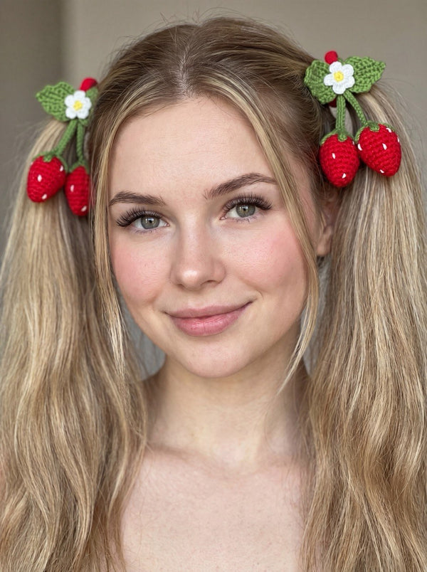 Handmade crochet strawberry hair ties worn in pigtails